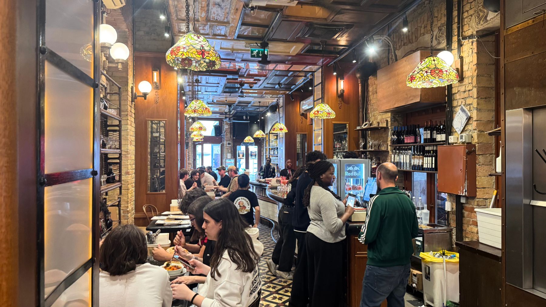 ステンドグラスの照明が灯るMama Goulashの賑わう店内
