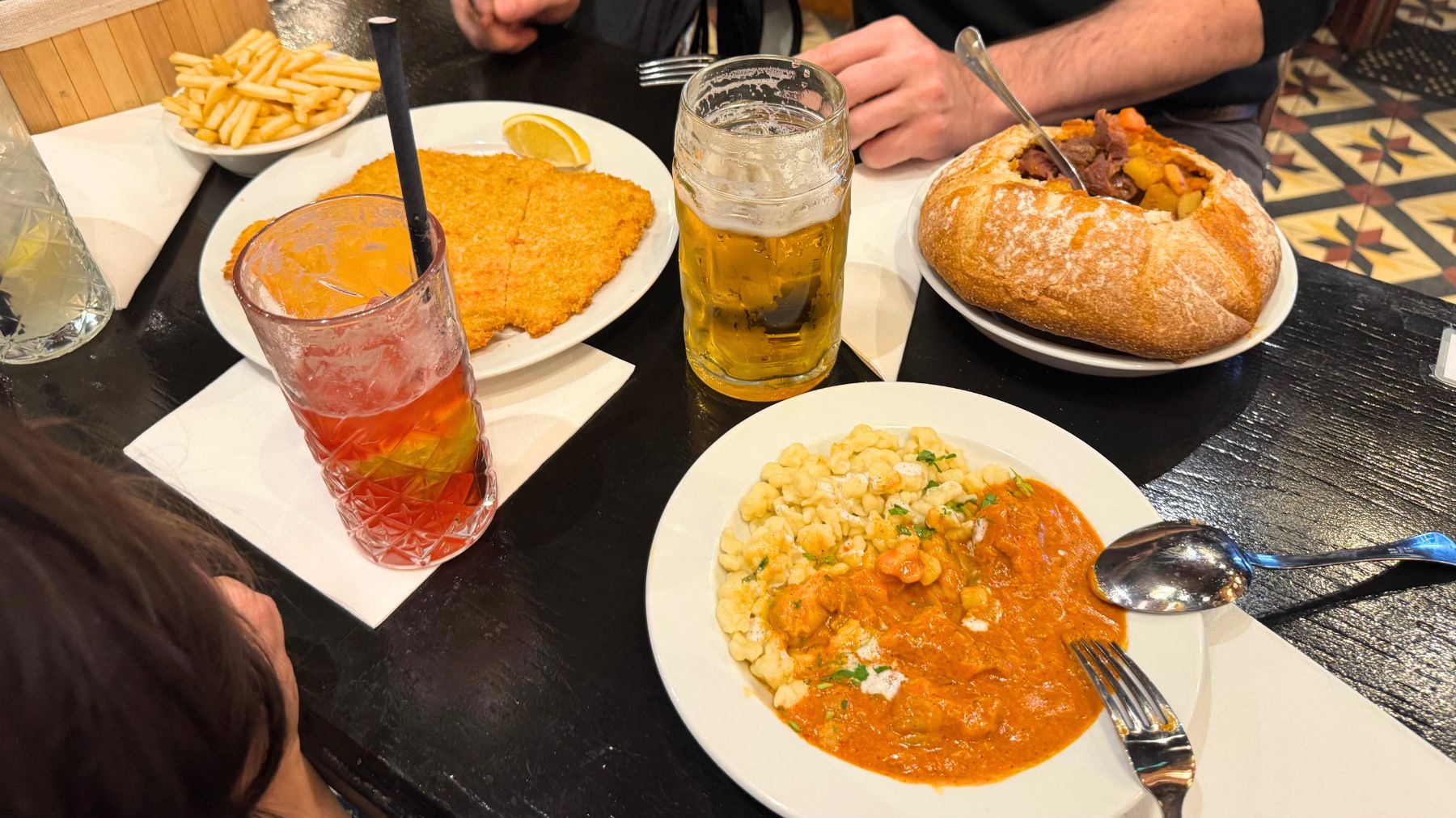テーブルに並んだグヤーシュ・シュニッツェル・パプリカーシュとドリンク