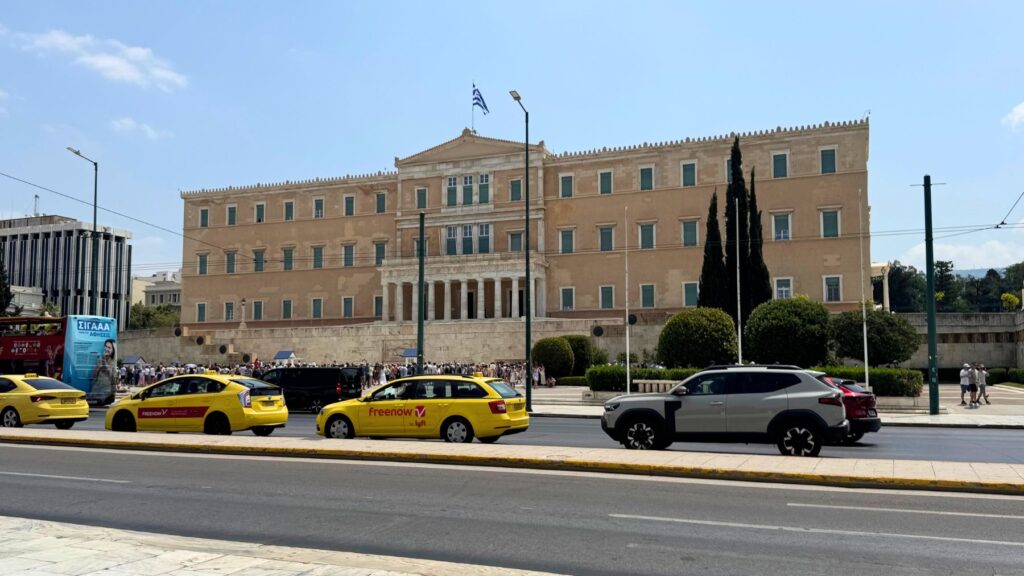 シンタグマ広場に面したギリシャ国会議事堂と黄色いタクシー