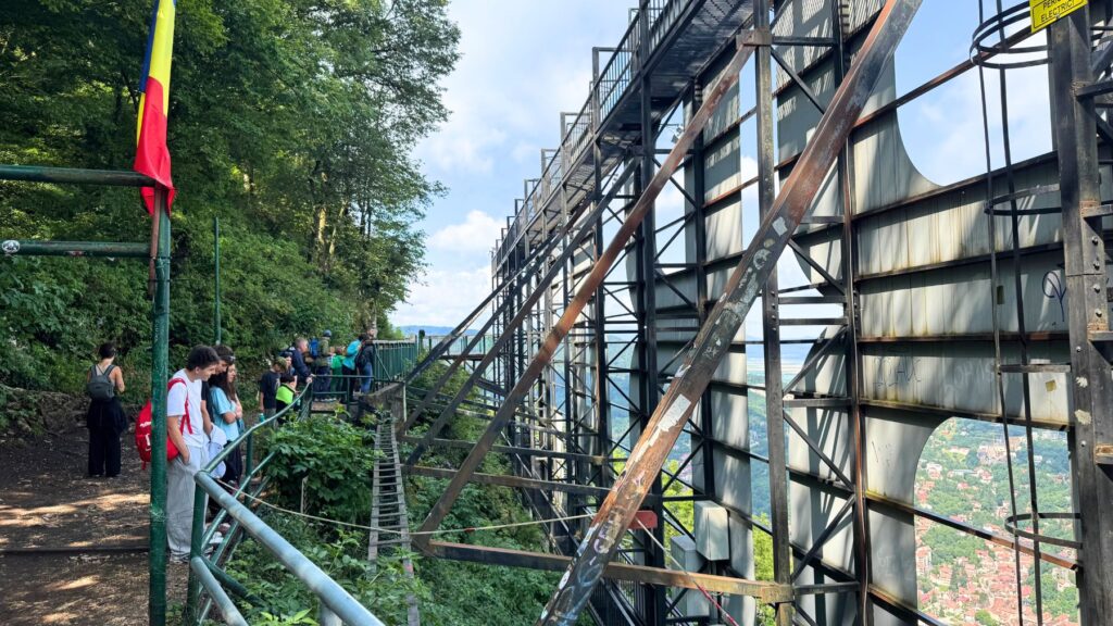 裏側から見た「BRAȘOV」の看板の鉄骨と眼下の町