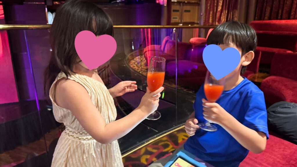 船内のラウンジでノンアルコールカクテルを手に乾杯する子どもたち