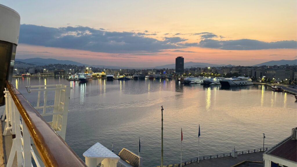 船のデッキから望むピレウス港の夕暮れ。停泊するフェリーの灯り
