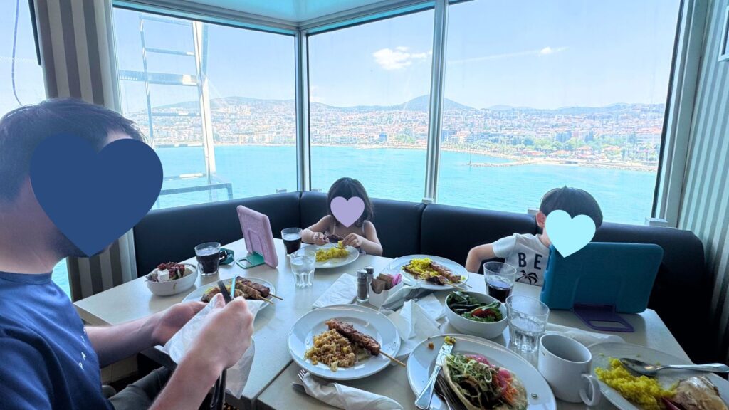 The Tavernaの窓側の席で港の景色を眺めながら食事する家族