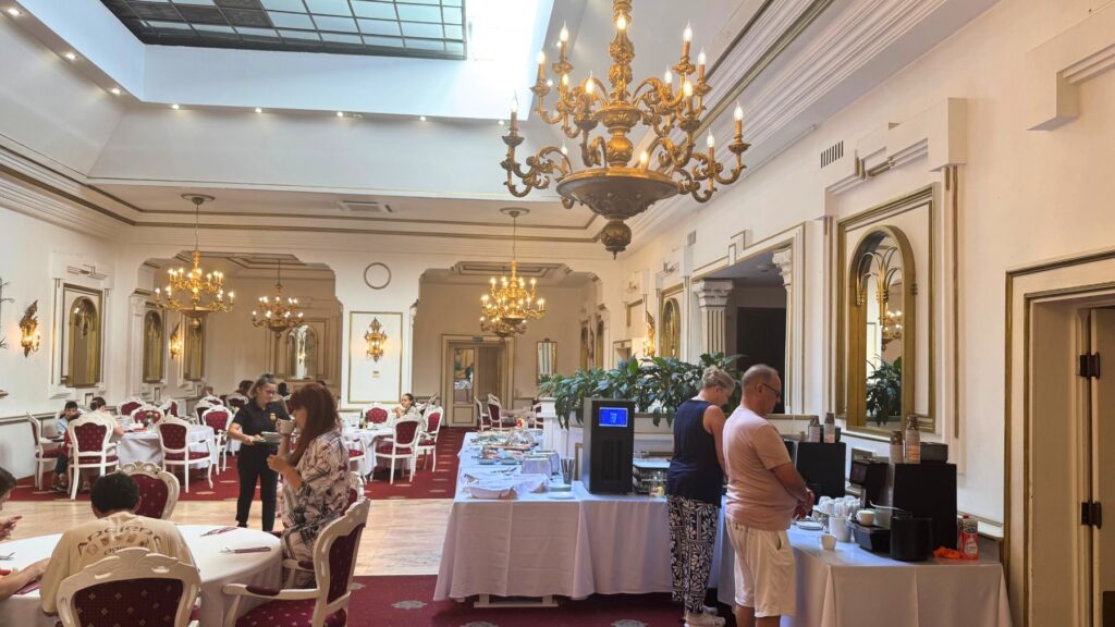 Hotel Împăratul Romanilor の朝食会場。シャンデリアの下がるレストランでビュッフェが並ぶ