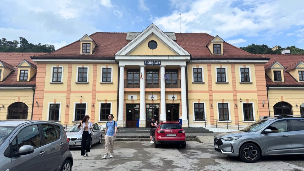 シギショアラ駅の黄色い駅舎とルーマニア国旗