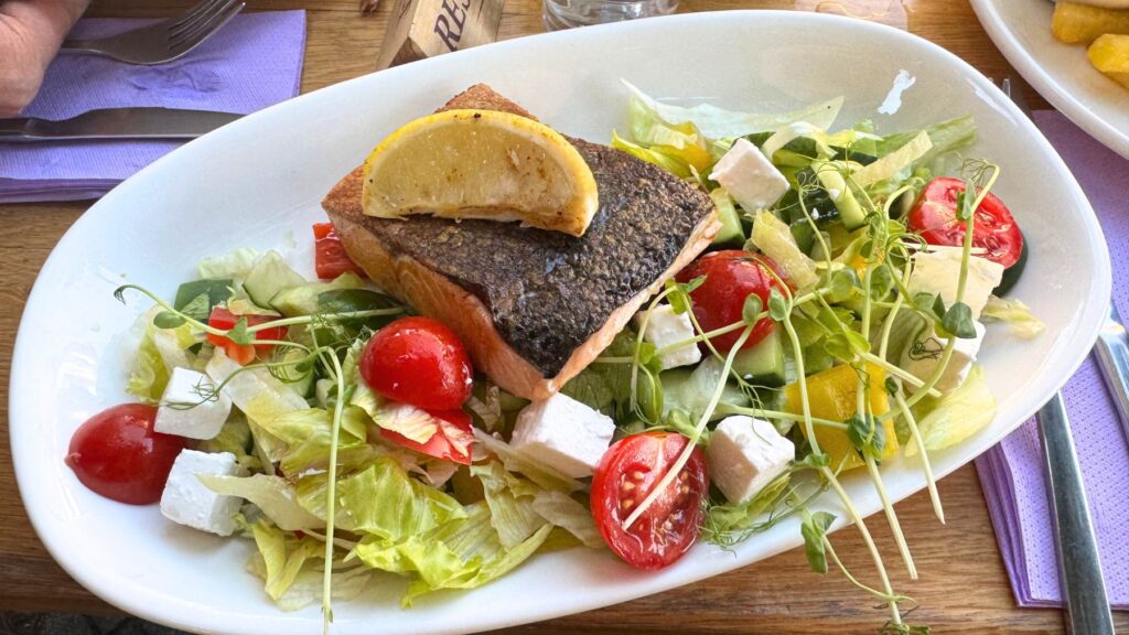 レストランItt és Most のサーモン料理。皮目を香ばしく焼いたサーモンに、フェタチーズやトマトのサラダを添えた一皿