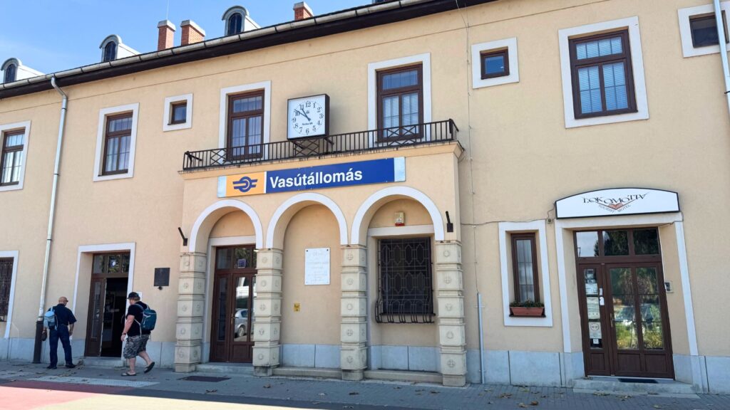 エゲル駅(Vasútállomás)の駅舎。黄色い外壁とアーチの入口、時計が印象的な建物
