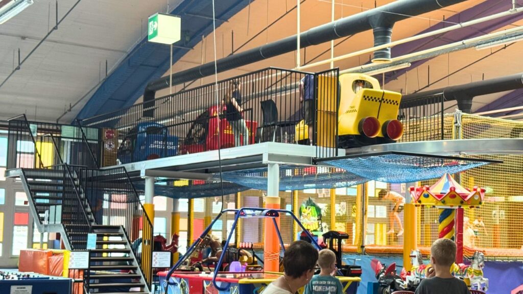上階に並ぶタクシーや消防車のライド遊具と階段