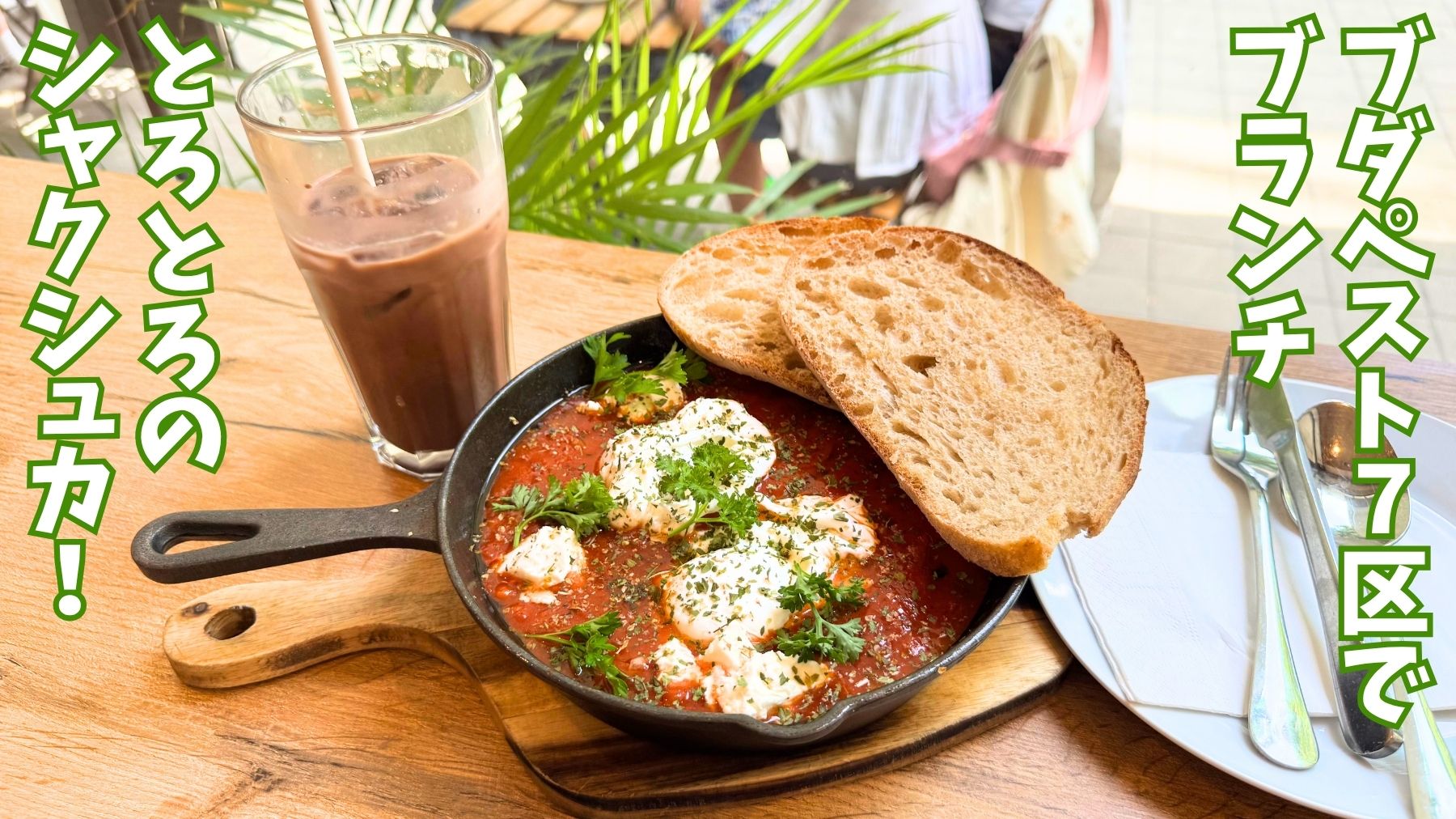 ブダペスト7区にあるカフェEGGIのブランチ。シャクシュカの赤いソースと白い卵やチーズが色鮮やか。パンが2枚のってアイスモカが添えられている。