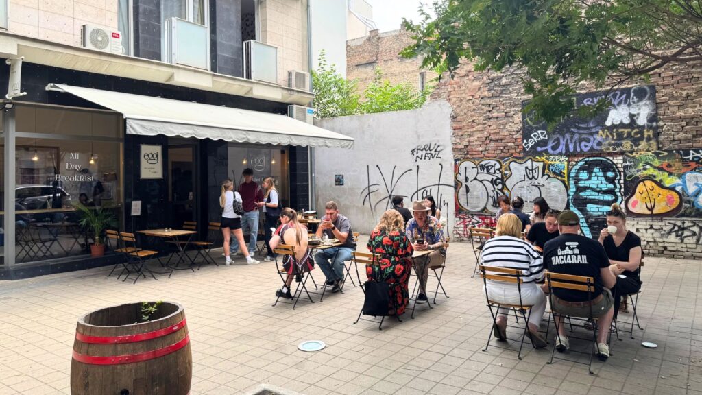 グラフィティの壁に面したEGGI Breakfast & Coffeeのテラス席と外観