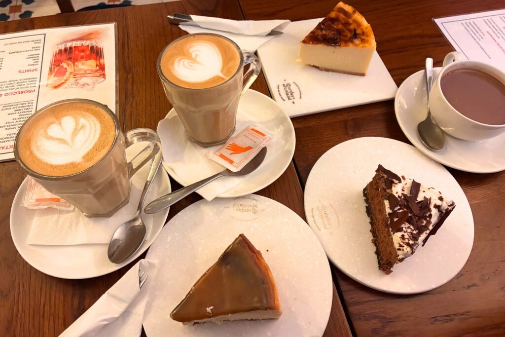 バレッタのSUNDAY IN SCOTLANDで注文したチーズケーキなど3種類のケーキと、ラテアートを施したコーヒーやカップに入ったドリンク。