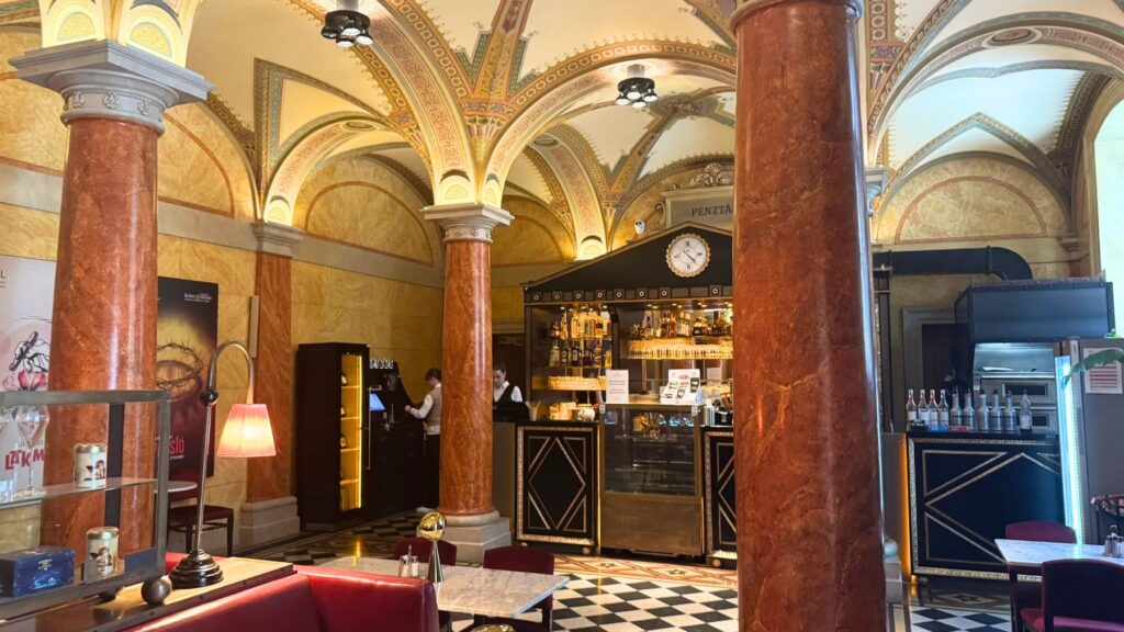 ブダペストのオペラ座内にあるOpera Bistroの店内。装飾されたアーチ天井と赤褐色の柱、奥のバーカウンター
